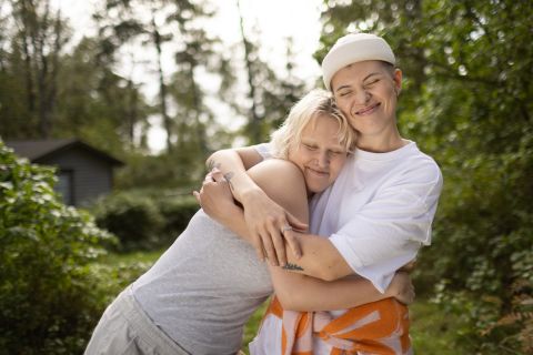 Work in Finlandin ja Business Finlandin brändikuva, jossa kaksi henkilöä halaavat ja hymyilevät.