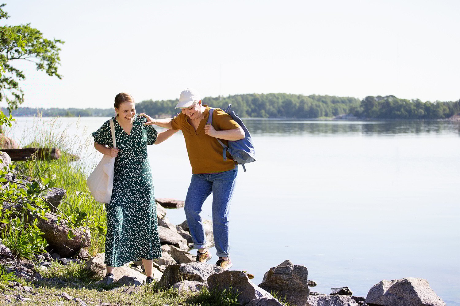 Kaksi henkilöä meren rannalla kesällä.