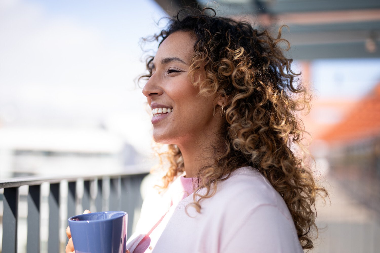 A woman on a sunny balcony.