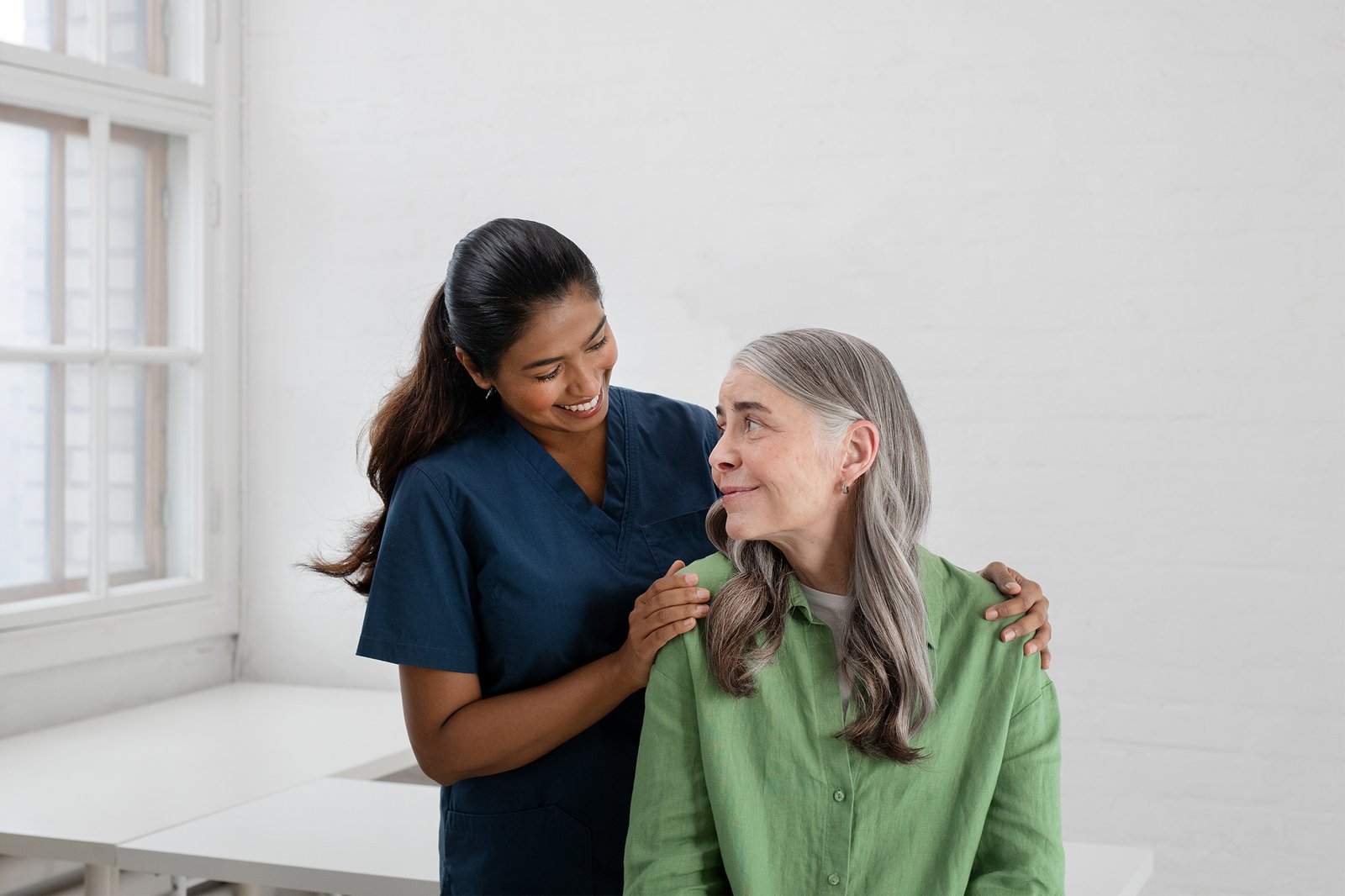 Hoitaja ja henkilö katsovat toisiinsa.