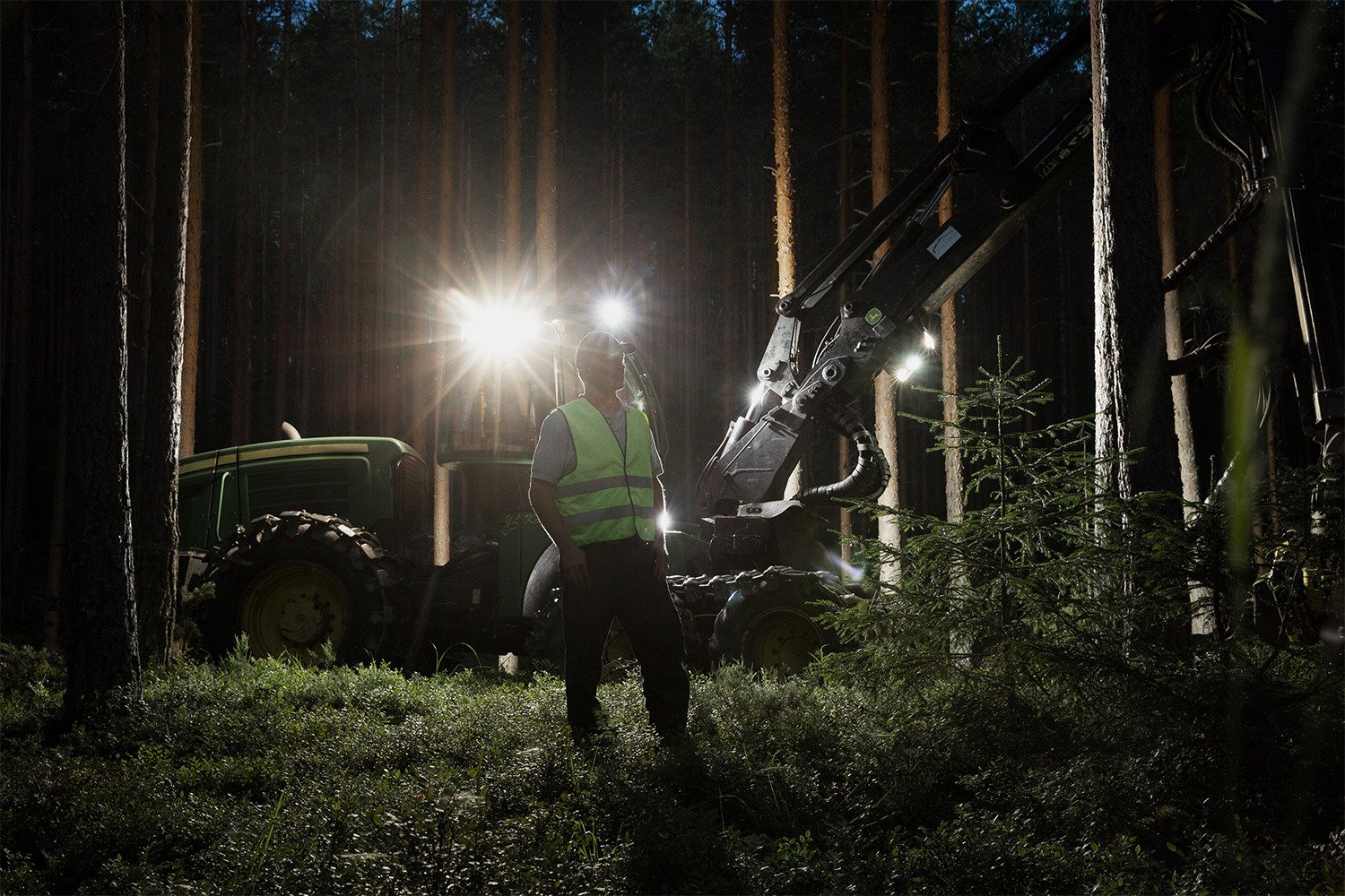 Henkilö metsätyökoneen edessä.