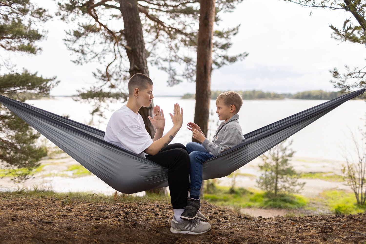 Aikuinen ja lapsi riippumatossa.