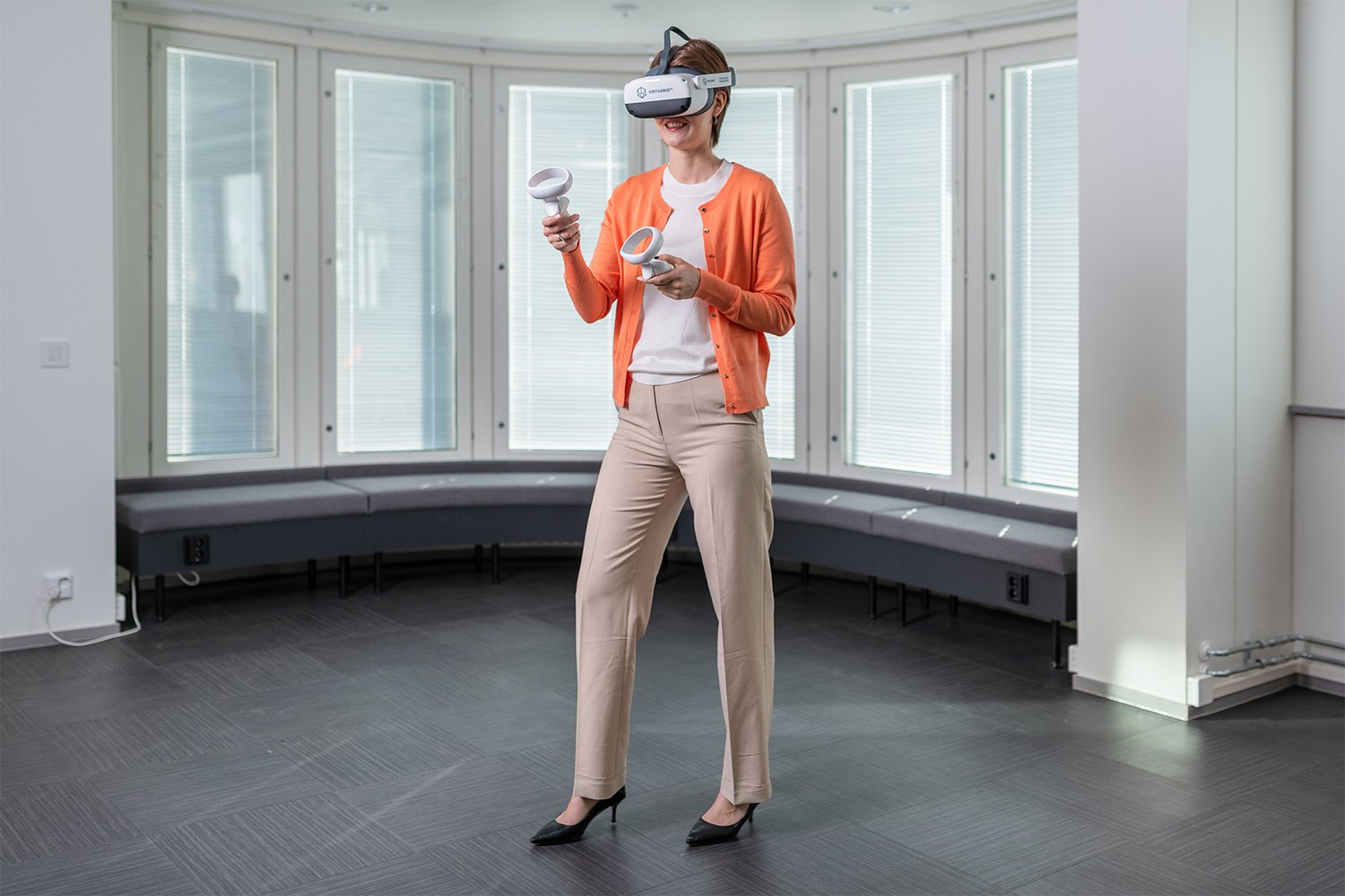 Henkilöllä on VR-lasit päässä ja käsissä ohjaimet.