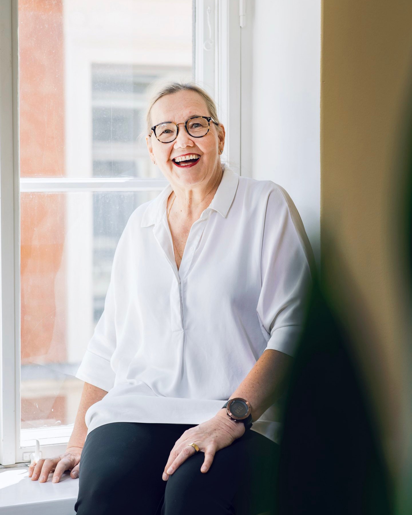 The person is sitting and smiling broadly.